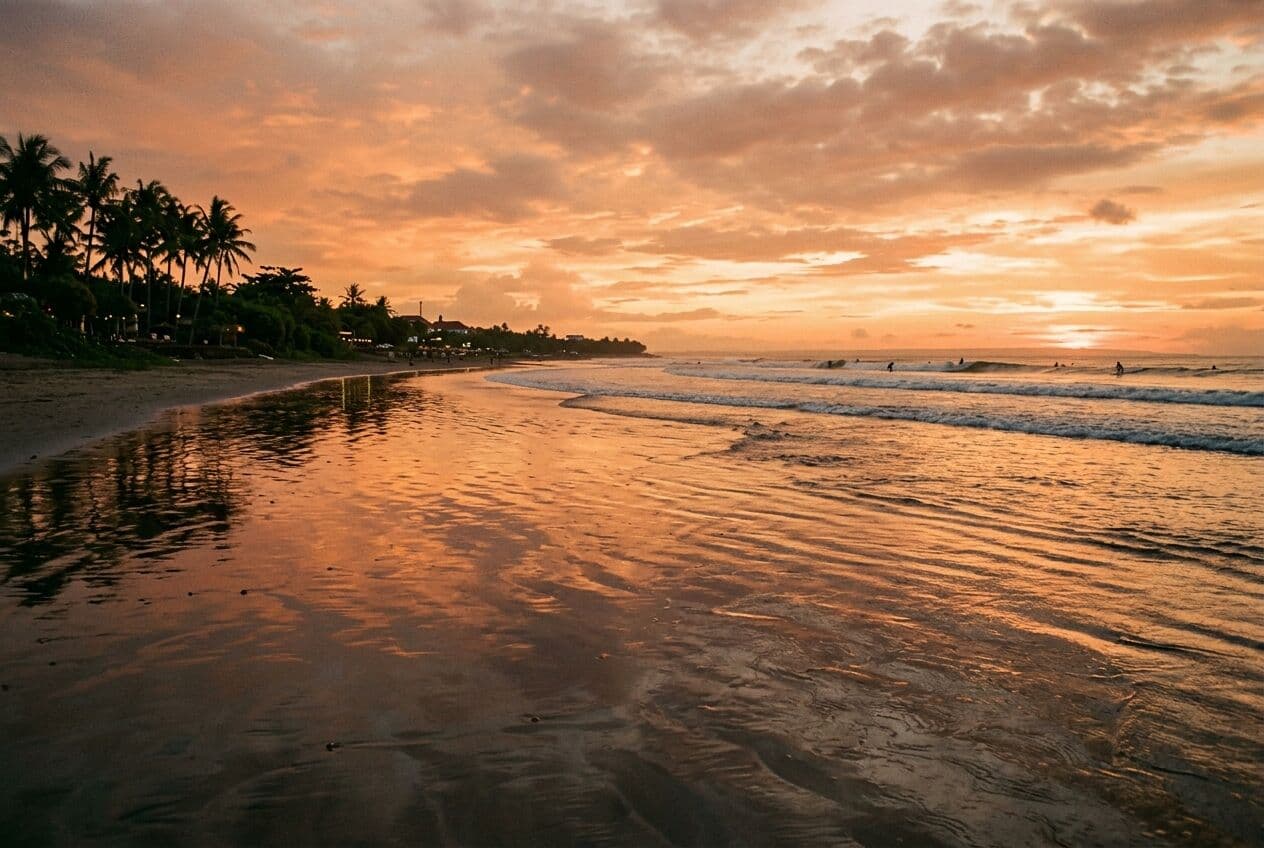 Illustration of Kuta Beach in Bali at sunset, wet sand reflecting an orange sky, palms along the shore.